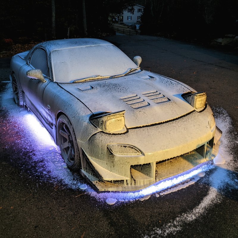 Foam-covered sports car during a mobile detailing wash